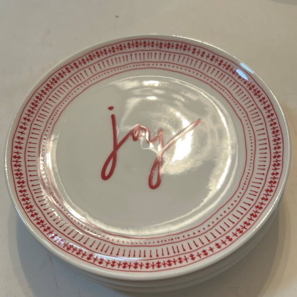 Four 6 inch Christmas plates by Ellen DeGeneres along with four new napkins